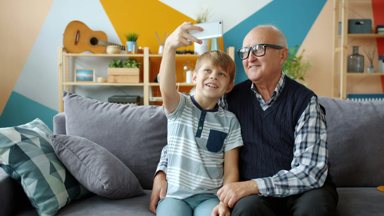 An older man and a child taking a selfie together.